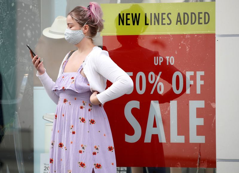 © Reuters. A woman wearing a face covering talks on her phone outside a shop following the outbreak of the coronavirus disease (COVID-19)  in Liverpool, Britain