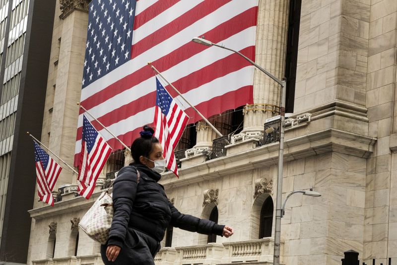 © Reuters. FILE PHOTO: A pedestrian with a mask walks past of the NYSE as markets continue to react to the coronavirus disease (COVID-19) at the NYSE in New York