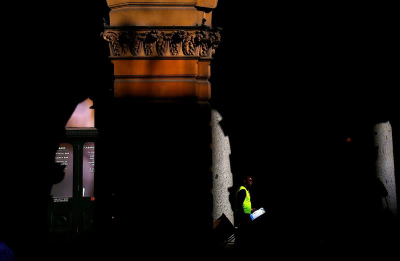 &copy; Reuters. A worker walks through the archway of a historical building as he delivers parcels in central Sydney