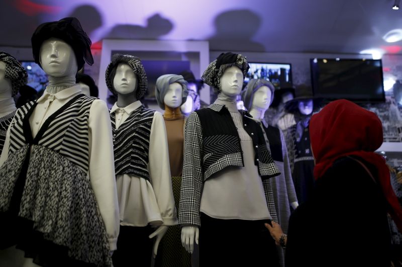 &copy; Reuters. A woman looks at clothing on display at a booth at Indonesia Fashion Week in Jakarta, Indonesia