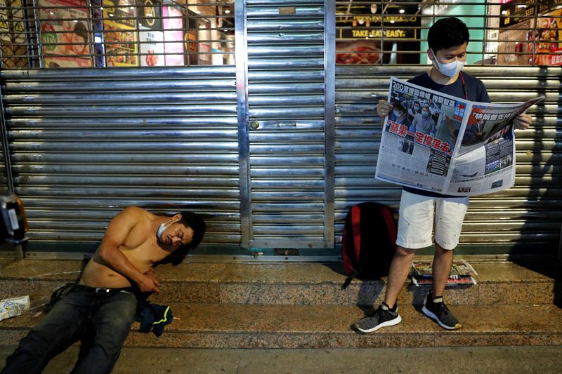© Reuters. A supporter of Apple Daily newspaper, reads a copy of Apple Daily newspaper to support media mogul Jimmy Lai Chee-ying, founder of Apple Daily after he was arrested by the national security unit, in Hong Kong