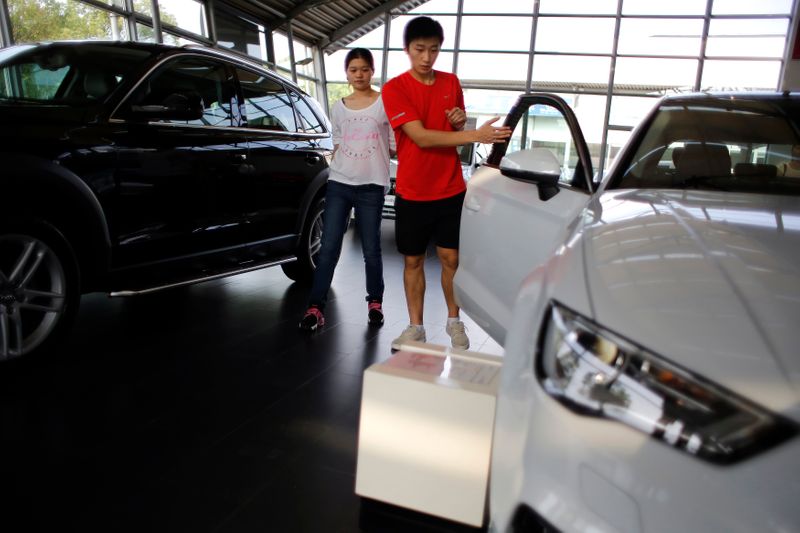 &copy; Reuters. Посетители осматирвают автомобиль в автосалоне Audi в Шанхае