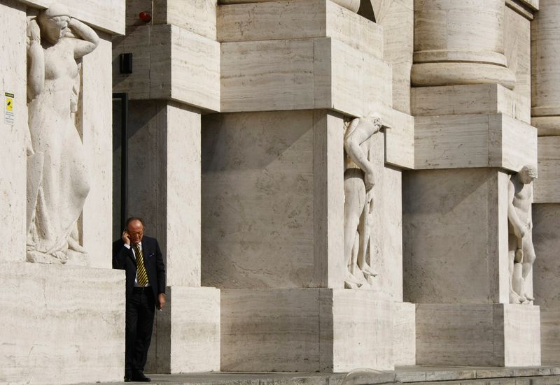 &copy; Reuters. Un uomo parla al telefono davanti all&apos;ingresso del palazzo della Borsa di Milano