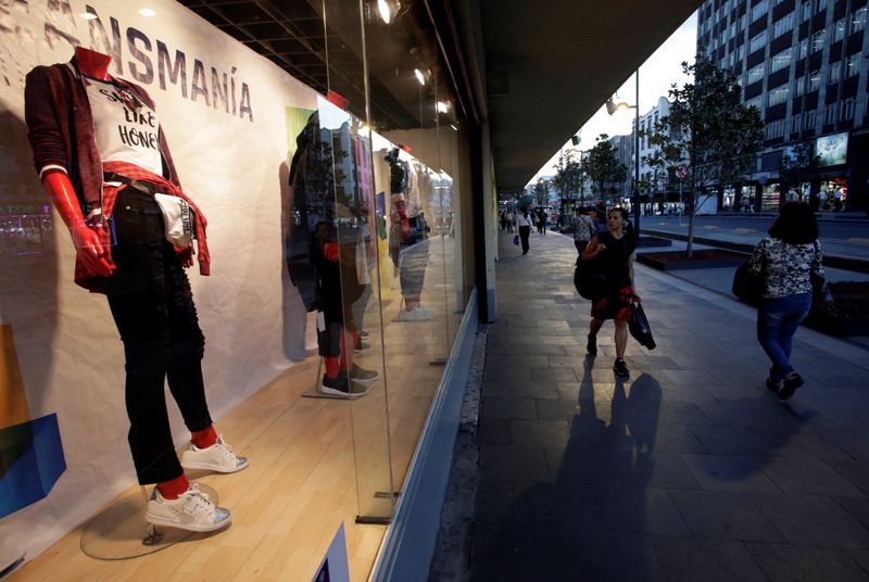 &copy; Reuters. People walk by a shop window at a deparment store in Mexico City