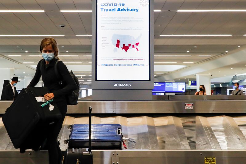 &copy; Reuters. A sign alerts travelers to the danger of COVID-19 at LaGuardia Airport, during the outbreak of the coronavirus disease (COVID-19), in New York