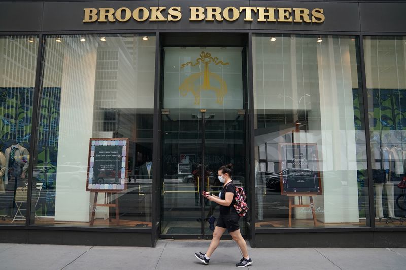 &copy; Reuters. Una donna con indosso la mascherina passa accanto a un punto vendita Brooks Brothers durante l&apos;epidemia di coronavirus a Manhattan