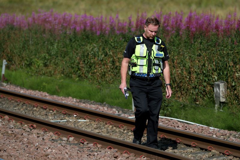 &copy; Reuters. Un policia junto a la zona en la que el tren descarriló en Carmont, Stonehaven, Escocia, dejando al menos tres muertos