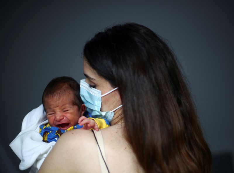 &copy; Reuters. Emmanuelle Lteif Khnaisser who was in labour at the moment of the Beirut port blast, holds her baby George at the family home in Jal el-Dib