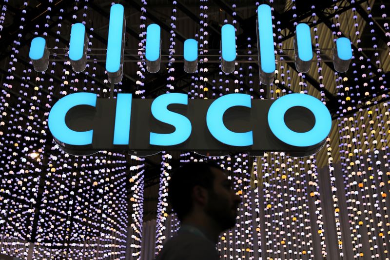 &copy; Reuters. A man passes under a Cisco logo at the Mobile World Congress in Barcelona