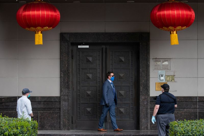 © Reuters. Plain clothes U.S. security officials surround the entrance of China’s Consulate after Chinese employees left the building, in Houston