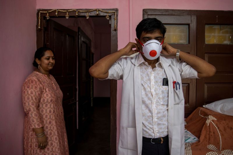 © Reuters. Médico indiano Kumar Gaurav põe equipamento de proteção contra coronavírus antes de ir para hospital