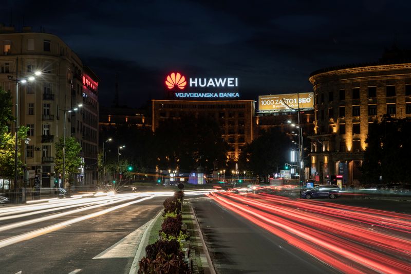 &copy; Reuters. Cars drive past a Huawei logo on a building in central Belgrade