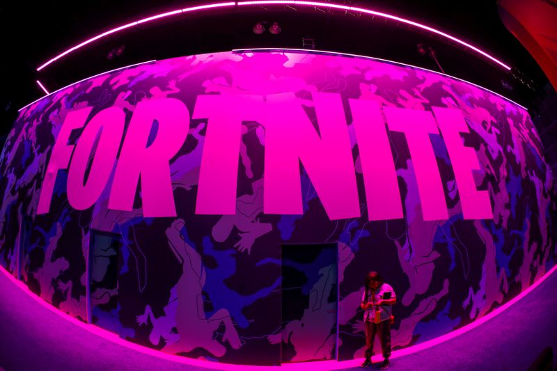 © Reuters. FILE PHOTO: An attendee stops to text next to Epic Games Fortnite sign at E3, the annual video games expo revealing the latest in gaming software and hardware in Los Angeles