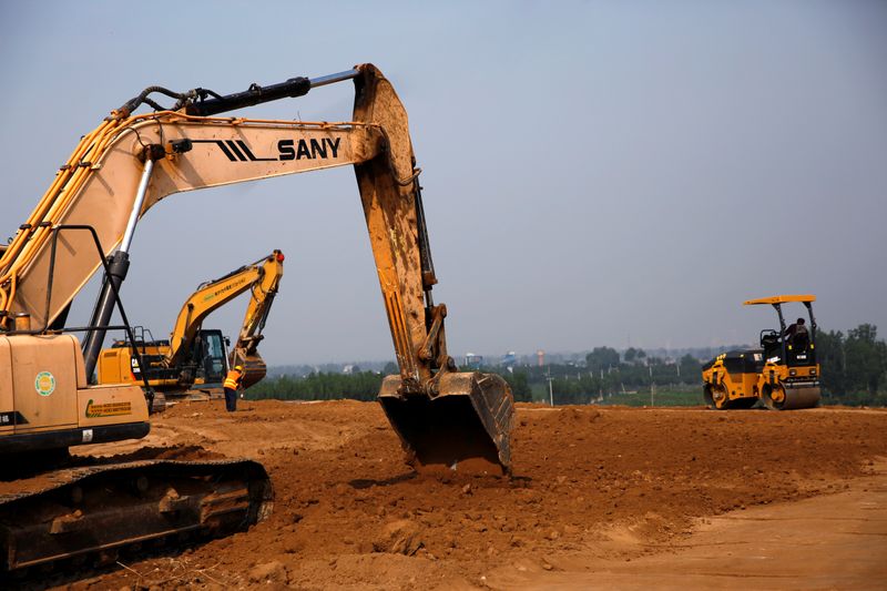 &copy; Reuters. Workers operate excavators to prepare land for a new pig farm in Beijing&apos;s eastern Pinggu district