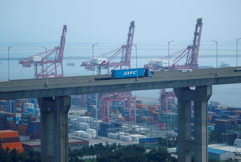 &copy; Reuters. A truck carrying a shipping container travels past cranes at Pyeongtaek port in Pyeongtaek