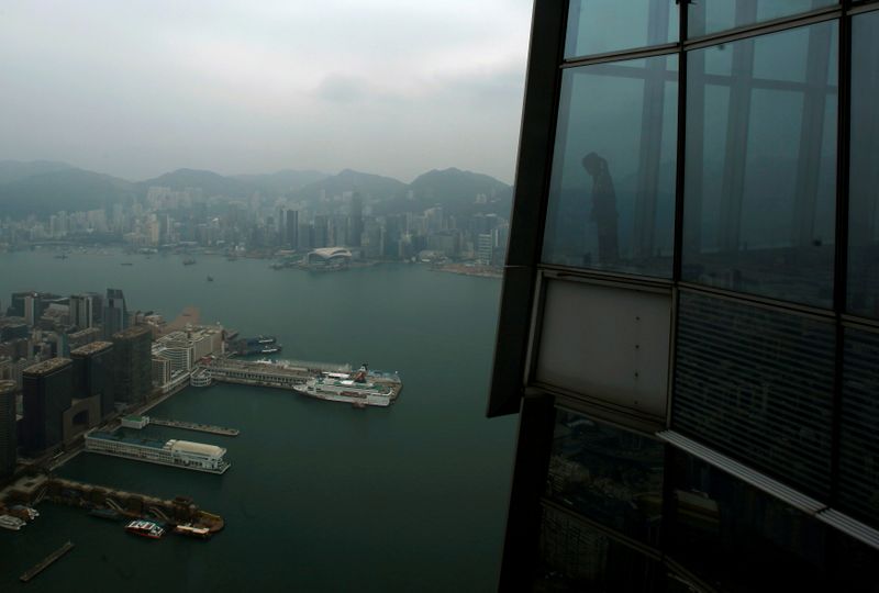 &copy; Reuters. A worker at &quot;sky100&quot; looks at Hong Kong&apos;s Victoria Harbour