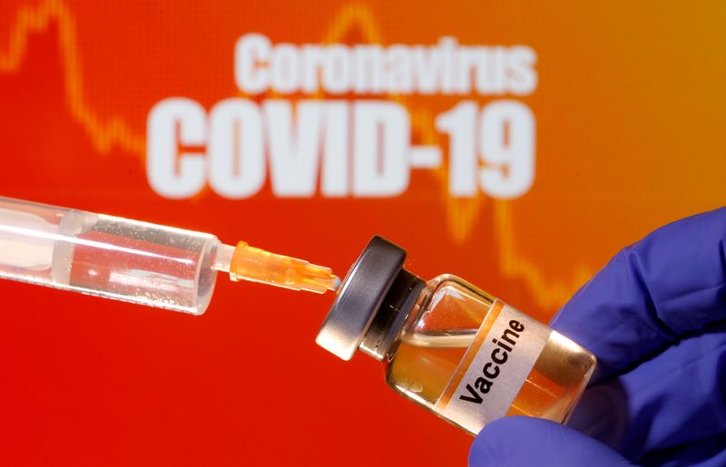 &copy; Reuters. FILE PHOTO: A small bottle labeled with a &quot;Vaccine&quot; sticker is held near a medical syringe in front of displayed &quot;Coronavirus COVID-19&quot; words in this illustration