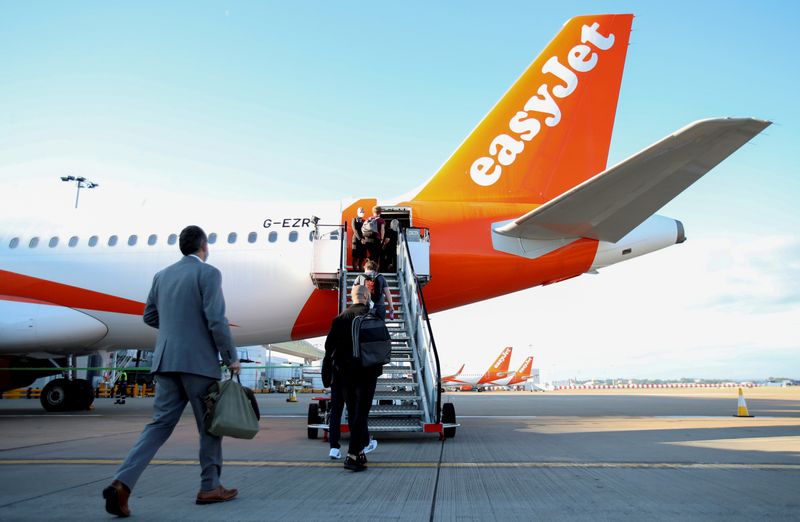 &copy; Reuters. FILE PHOTO: Passengers board a plane as easyJet restarts its operations at Gatwick Airport