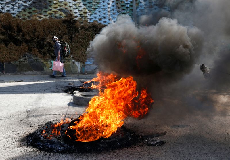 © Reuters. Homem passa por pneus em chamas após bloqueio feito por manifestates em El Alto, na Bolívia