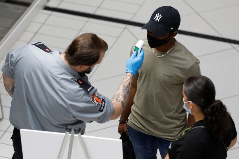 &copy; Reuters. A security guard takes a person&apos;s temperature at the Rideau Centre in Ottawa