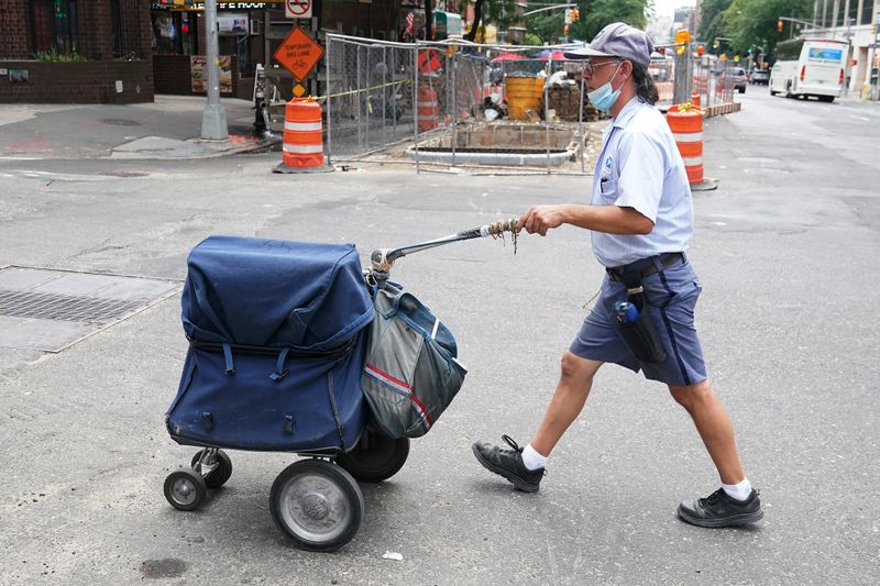 &copy; Reuters. FILE PHOTO: USPS worker walks with his cart in New York City