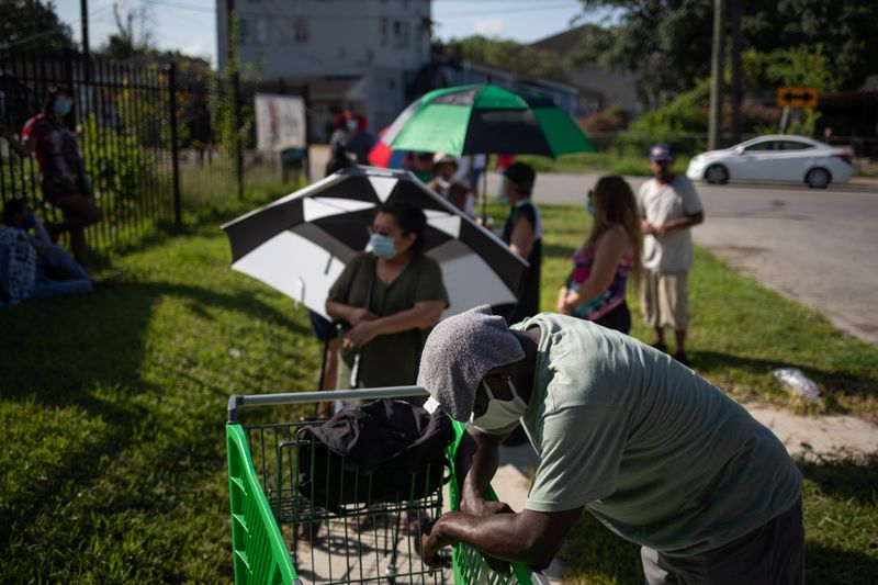 &copy; Reuters. Varias personas hacen cola a la espera de recibir alimentos para los afectados por la crisis económica motivada por la COVID-19