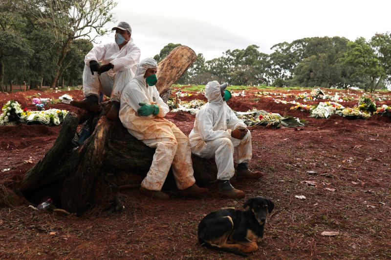 &copy; Reuters. Agentes sepultadores com trajes de proteção durante pandemia de Covid-19 no cemitério de Vila Formosa, em São Paulo