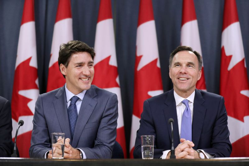 © Reuters. FILE PHOTO: Canada's PM Trudeau and Finance Minister Morneau react during a news conference  in Ottawa