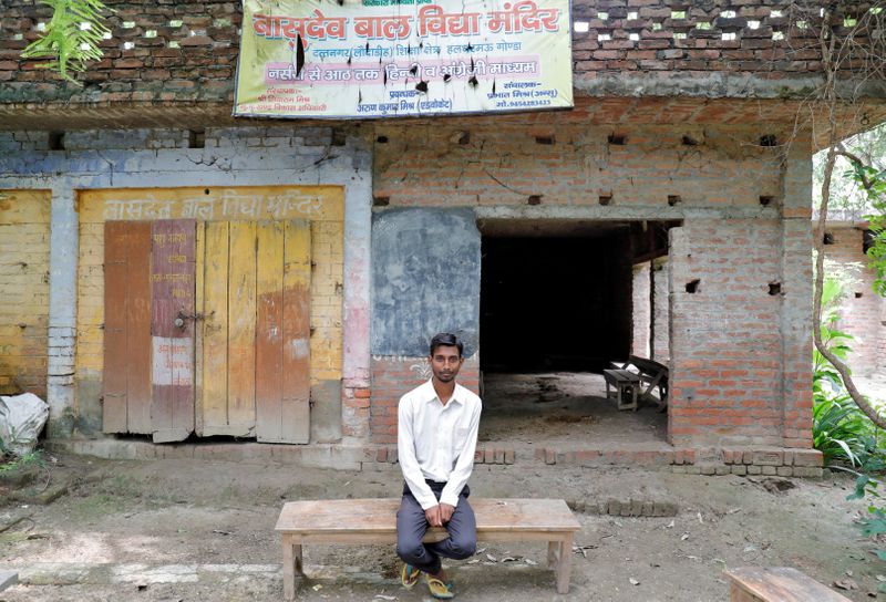 &copy; Reuters. Ashish Kumar poses outside a primary school where he studied in Dutta Nagar