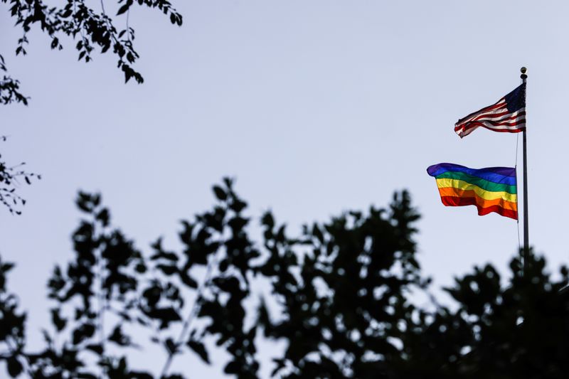 &copy; Reuters. A rainbow pride flag is seen with the U.S. national flag at a building ahead of the 50th anniversary of the Stonewall riot, in New York