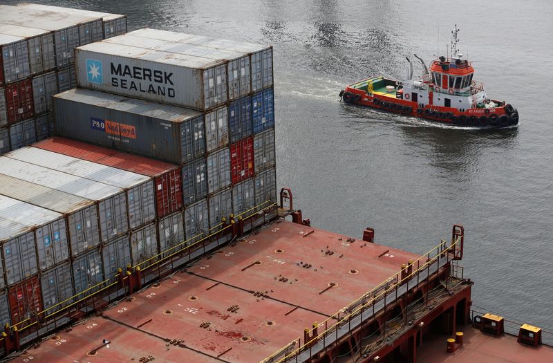 &copy; Reuters. A tugboat sails past a container ship in Tanjung Priok Port, Jakarta,