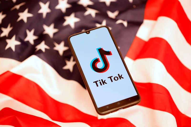 &copy; Reuters. Imagen de archivo ilustrativa del logo de TikTok en la pantalla de un teléfono móvil puesto junto a una bandera de Estados Unidos