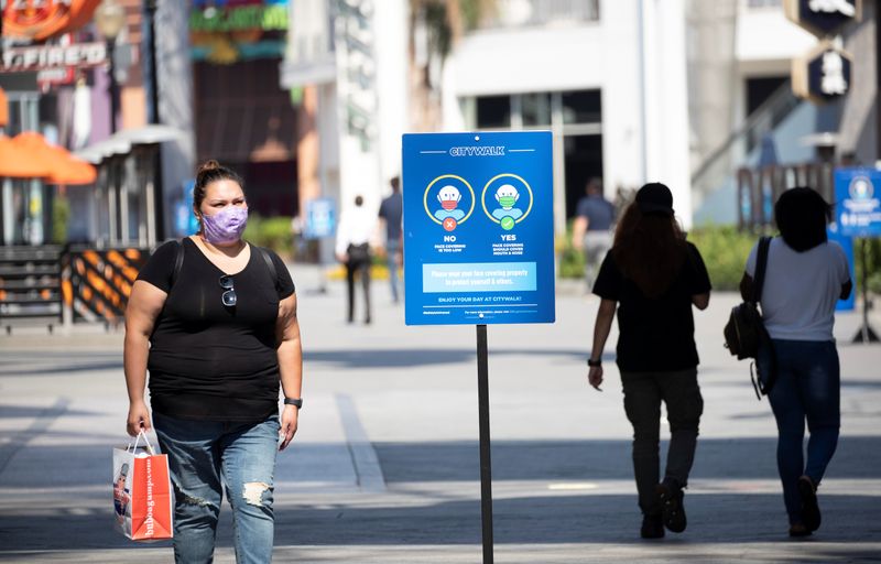 &copy; Reuters. A person wearing a face mask walks through Universal CityWalk Hollywood during the outbreak of the coronavirus disease (COVID-19), in Universal City