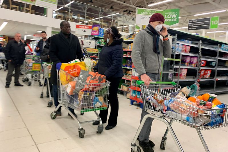 &copy; Reuters. FILE PHOTO: Shoppers queue at a supermarket in London