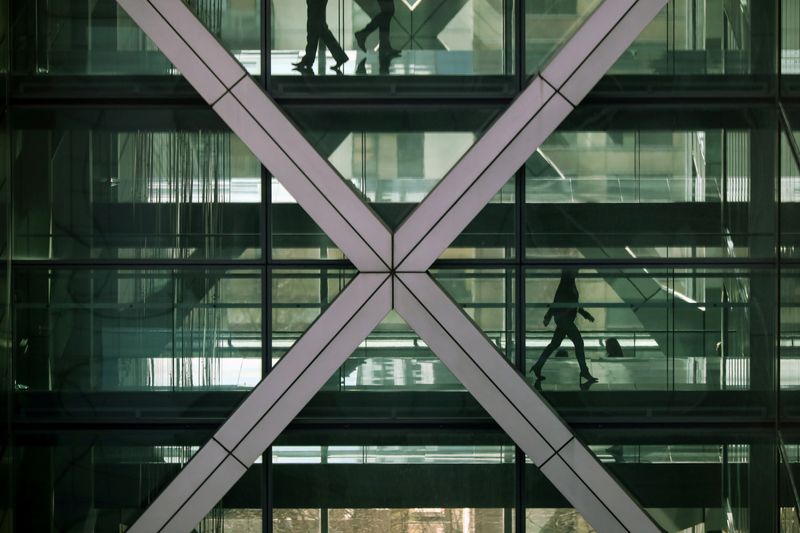 &copy; Reuters. FILE PHOTO: People walk in an office in the financial centre of Canary Wharf