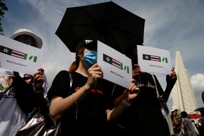 &copy; Reuters. Protesters hold signs of the Hong Kong-Thailand-Taiwan network (Milk Tea Alliance) during a rally to demand the government to resign, to dissolve the parliament and to hold new elections under a revised constitution, in Bangkok