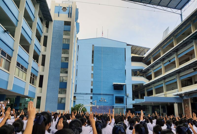 &copy; Reuters. Students make three-finger salutes during the national anthem, as they show support for the student-led democracy movement at a school in Bangkok