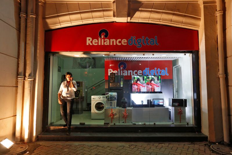 © Reuters. An employee leaves a store of Reliance Industries Ltd, controlled by Mukesh Ambani, one of India's richest men, at a market in Kolkata