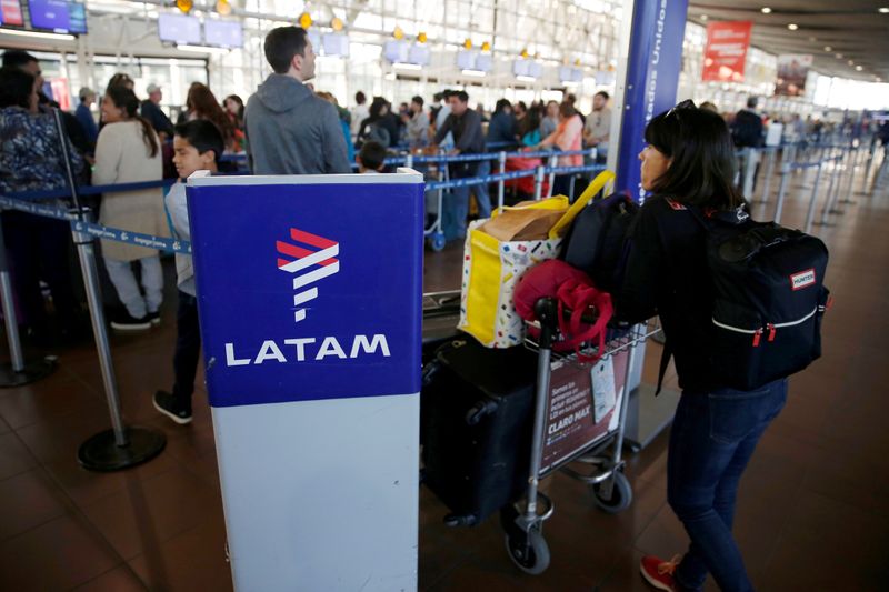© Reuters. FILE PHOTO: Passengers wait to check in for their flights at the departure area of Latam airlines inside of the Commodore Arturo Merino Benitez International Airport in Santiago