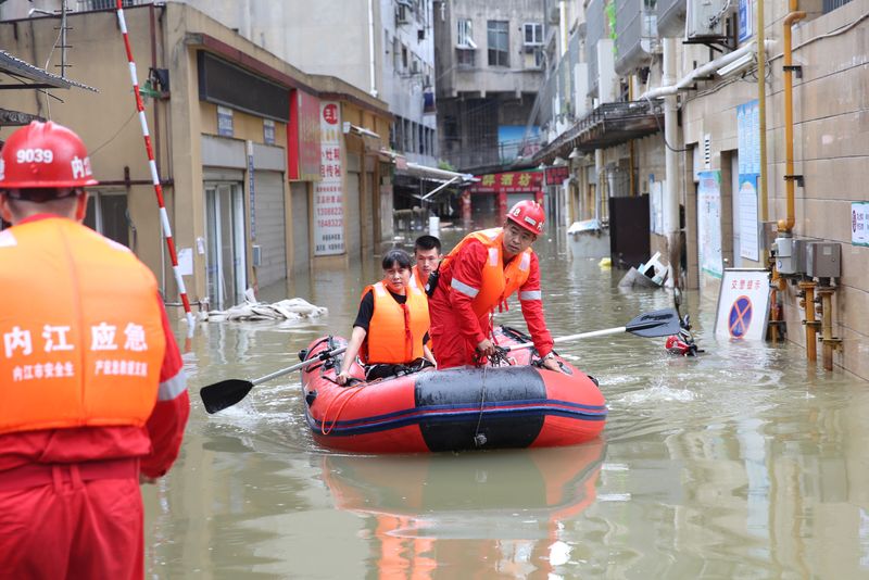 &copy; Reuters. Rescue workers evacuate a resident stranded by floodwaters following heavy rainfall in Neijiang of Sichuan