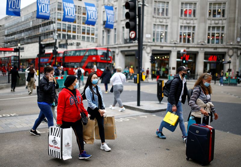 &copy; Reuters. FOTO DE ARCHIVO: Personas portando mascarillas caminan con bolsas de la compra en Oxford Circus, Londres