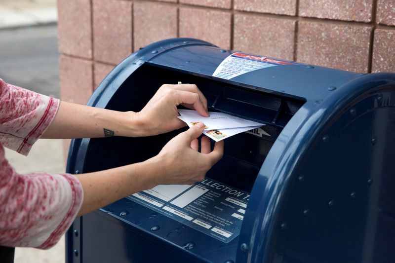 © Reuters. FILE PHOTO: An individual mails letters through the U.S. Postal Service (USPS) in Philadelphia