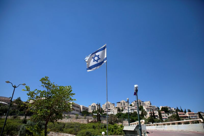 © Reuters. The Israeli national flag flutters as apartments are seen in the background in the Israeli settlement of Maale Adumim in the Israeli-occupied West Bank