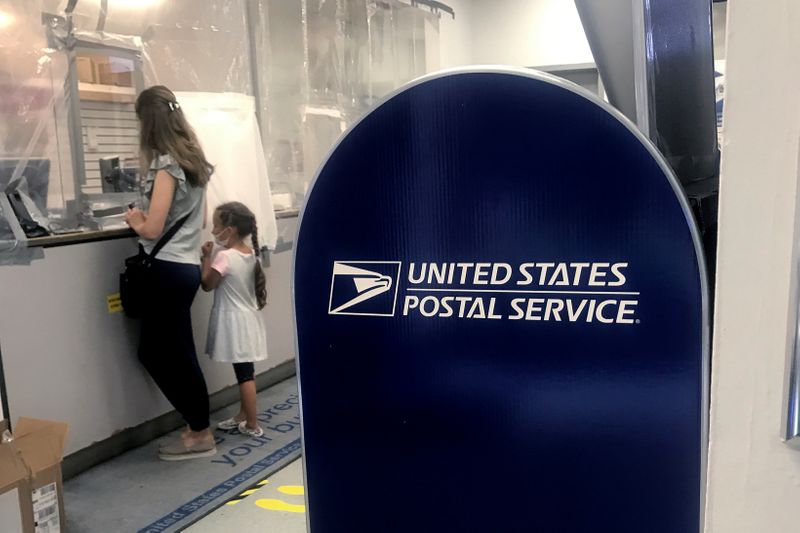 &copy; Reuters. A woman and child do business at the counter in a United States Post Office