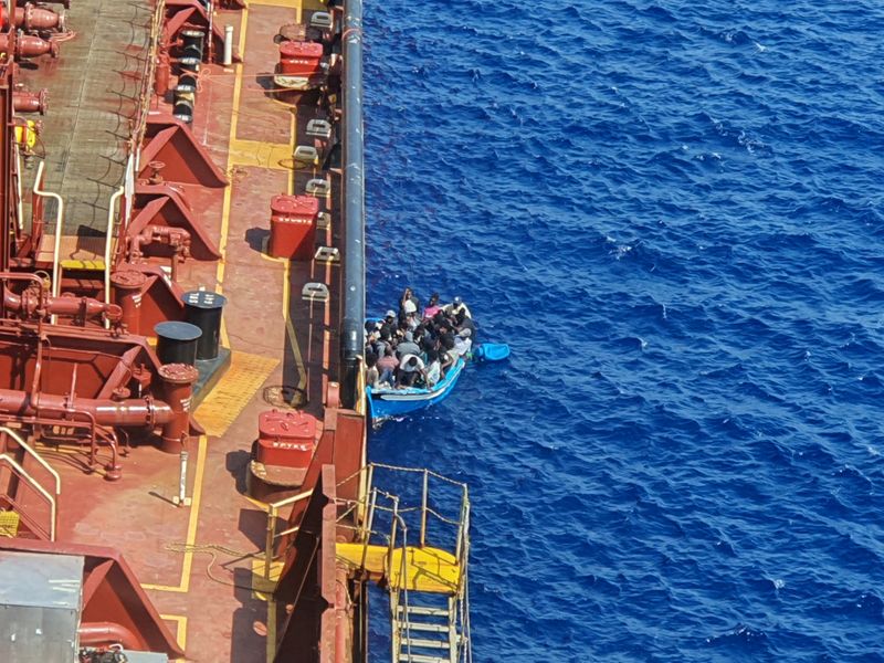 &copy; Reuters. Migrants sit in a boat alongside the Maersk Etienne tanker off the coast of Malta