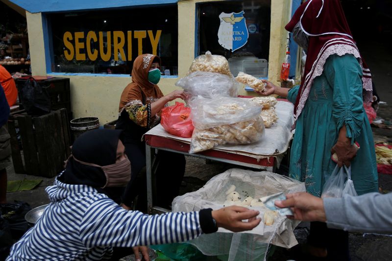 © Reuters. Vendors wearing protective masks serve their customers at a traditional market amid the coronavirus disease (COVID-19) outbreak in Jakarta