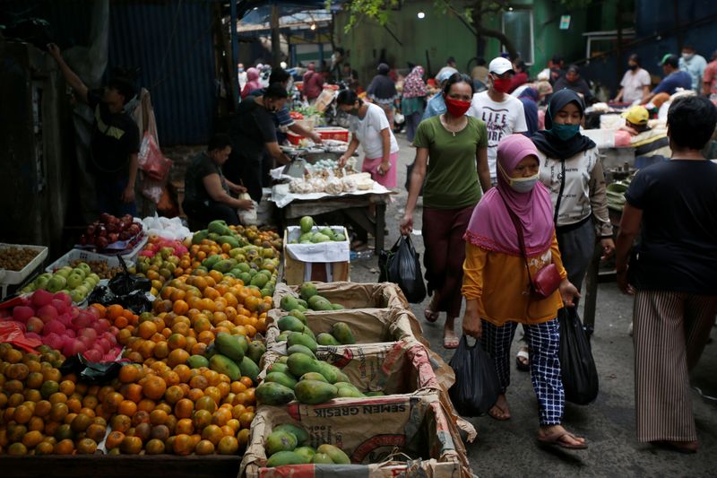 &copy; Reuters. People wearing protective masks shop at a traditional market amid the coronavirus disease (COVID-19) outbreak in Jakarta