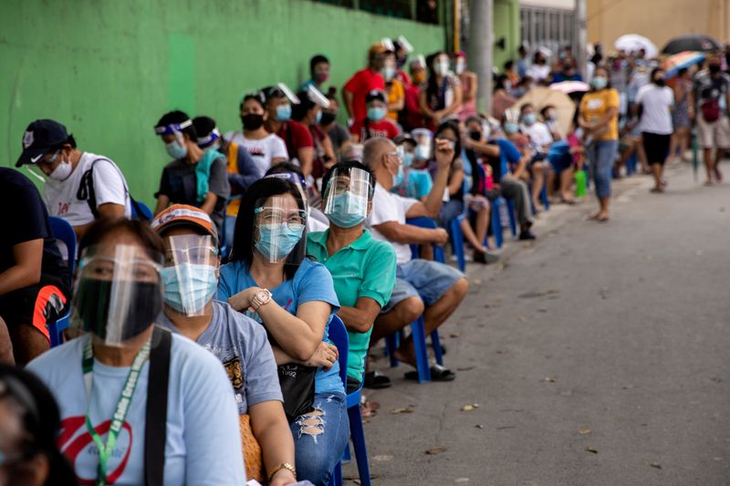 &copy; Reuters. Filipinos queue for government aid amid the coronavirus disease (COVID-19) outbreak, in Quezon