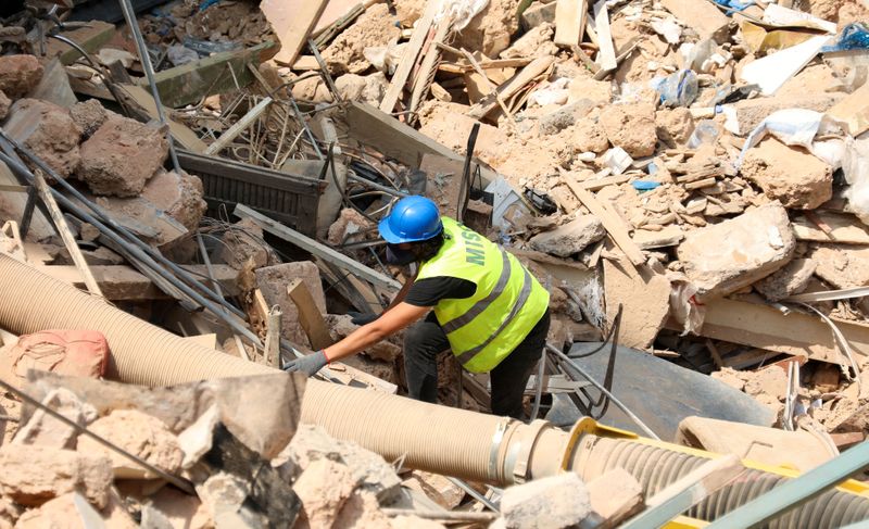 &copy; Reuters. FILE PHOTO: A volunteer digs through the rubble of buildings which collapsed due to the explosion at the port area, after signs of life were detected, in Gemmayze, Beirut