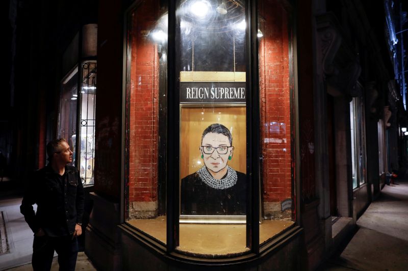 &copy; Reuters. A person looks towards a painting in a storefront on Broadway of Associate Justice of the Supreme Court of the United States Ruth Bader Ginsburg who passed away in Manhattan, New York City